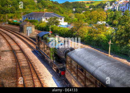 Grün-Dampfzug und Wagen im Bahnhof mit Eisenbahn Spuren im HDR wie Gemälde Stockfoto