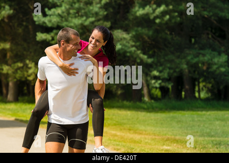 Sportlicher Freund geben Huckepack Fahrt zu seiner Freundin Stockfoto