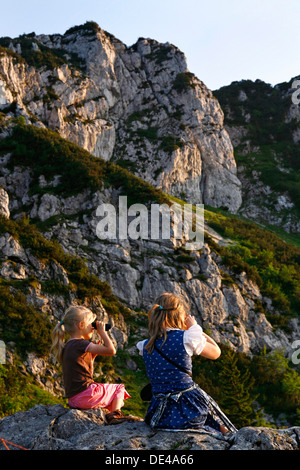 Mädchen auf der Suche durch Fernglas (Fernglas) auf dem Berg Kampenwand, Chiemgau-Oberbayern-Deutschland Stockfoto