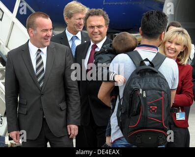 Hannover, Deutschland. 11. September 2013. Deutsche Bundesinnenminister Hans-Peter Friedrich (CSU, 3. L) und Niedersachsens Innenminister Boris Pistorius (SPD, L), sowie des niedersächsischen Kommissar für Migration und Partizipation, Doris Schröder-Koepf (SPD, R), Flüchtlinge aus Syrien bei der Ankunft am Flughafen in Hannover, Deutschland, 11. September 2013 begrüßen. Foto: Holger Hollemann/Dpa/Alamy Live News Stockfoto