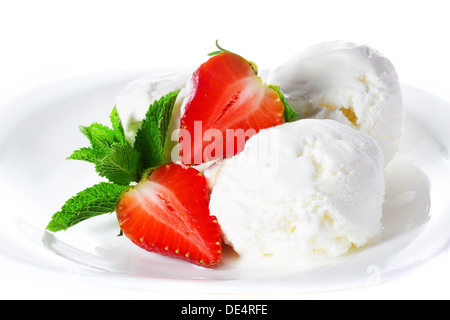 Vanilleeis mit Minze und Erdbeeren auf einem Teller auf weißem Hintergrund Stockfoto