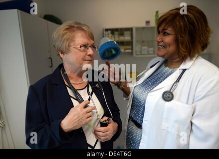 US-Arzt Elizabeth Beltre spricht mit ihrem Vorgänger Dagmar Teichert in ihrer Arztpraxis in Bermsgruen, Deutschland, 11. September 2013. Beltre übernahm die Praxis im Rahmen des Projekts Bienvenido; ein Projekt, mit dem das Bundesland internationale Ärzte arbeiten innerhalb des Staates zu gewinnen will. Beltre ist aus New York und Studium Medizin an der Universität Universidad Autonoma Santo Domingo in der Dominikanischen Republik. Foto: Hendrik Schmidt Stockfoto