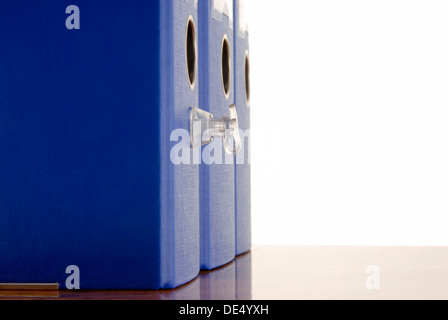 Blauen Aktenordner mit Ventil stehend auf dem Schreibtisch, symbolisches Bild für aufgeblasenen Bürokratie Stockfoto