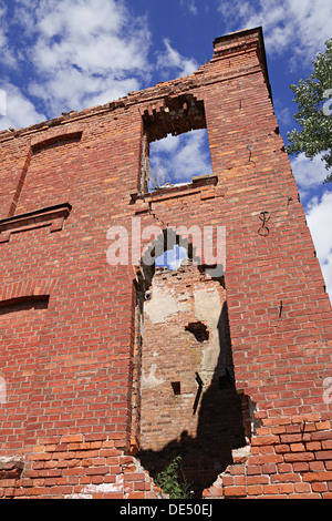 Blauer Himmel und einstürzende Mauer des alten Gebäudes Stockfoto