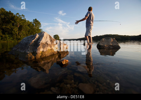 Ein Mann wirft seine Linie beim Angeln am See Windsor in Bella Vista, Arkansas. Stockfoto