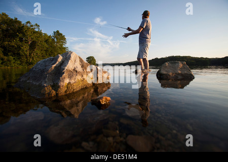 Ein Mann wirft seine Linie beim Angeln am See Windsor in Bella Vista, Arkansas. Stockfoto