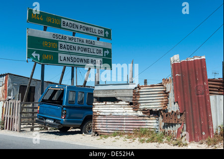 Blechhütten, Auto und Roadsign in in Khayelitsha, einem teilweise informellen Township in Kapstadt, Südafrika Stockfoto