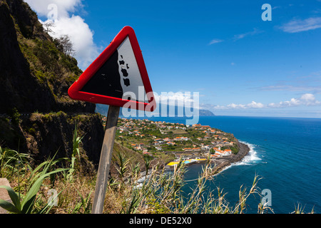 Melden Sie an, "Hütet euch vor Steinschlag" auf einer Landstraße entlang der Steilküste in der Nähe von Ponta Delgada, Vicente, Boaventura Madeira Stockfoto