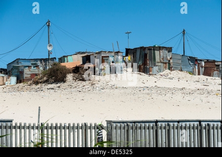 Blechhütten hinter einem Zaun in Khayelitsha, einem teilweise informellen Township in Kapstadt, Südafrika Stockfoto