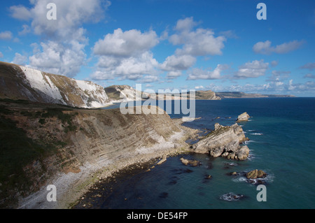 Die steilen Felswände des Dorset Jurassic Coast übersehen Mupe Bay, Mupe Felsen und Speck Loch mit seinem verlassenen steinigen Strand. England, United Kingdom. Stockfoto