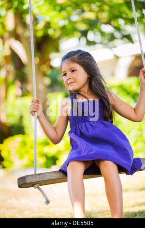 Niedliche kleine Mädchen auf der Schaukel spielen Stockfoto