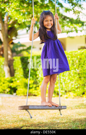 Niedliche kleine Mädchen auf der Schaukel spielen Stockfoto