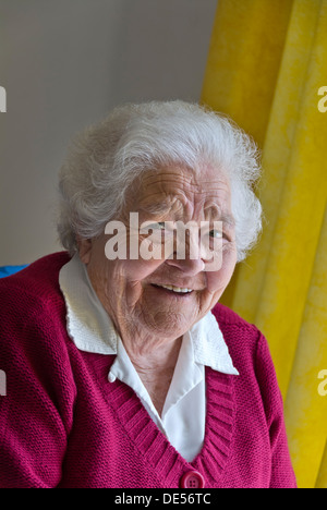 Porträt von glücklich lächelnd zufrieden ältere Dame in ihrem hellen luftigen Zimmer Stockfoto
