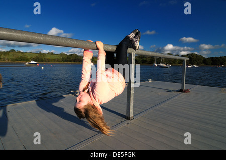 Mädchen von Geländern auf Ponton Fluss Teifi St. Dogmaels Wales kopfüber hängend Stockfoto