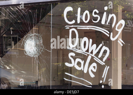 Schließung der Ankündigung geschrieben in großen weißen Lettern auf das Schaufenster eines leeren ehemaligen Möbel Shop Showroom in Bolton. Stockfoto