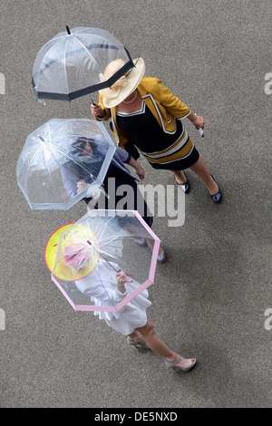 Ascot, UK, elegant gekleidet Frauen mit Regenschirm auf der Rennbahn Stockfoto