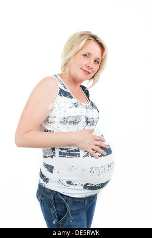 schönes Lächeln schwanger Frau zärtlich mit ihrem Bauch isoliert auf weißem Hintergrund Stockfoto