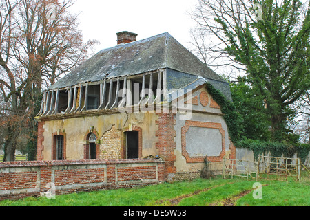 Verlassene Backsteinhaus hinter einem Zaun. Stockfoto