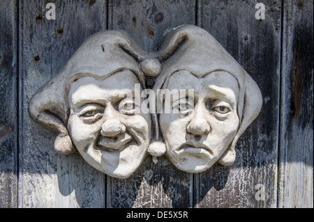 Commedia dell Skulptur Gesichter von Keramik auf eine Holztür, UK Stockfoto