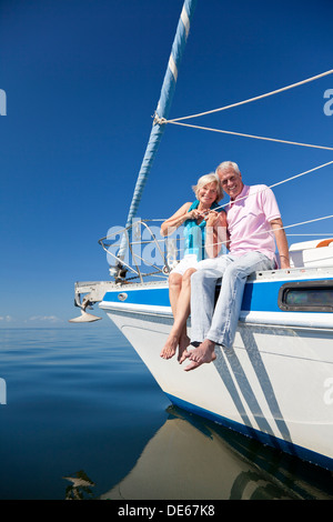Ein glückliches senior paar sitzen auf dem Deck eines Segelbootes auf einem ruhigen blauen Meer Stockfoto