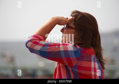 Frau in Rot kariertes Hemd, Blick auf den Himmel Stockfoto