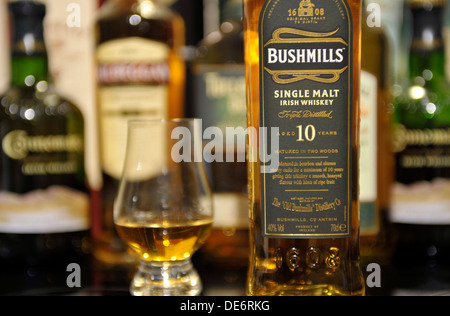 Bushmills Single Malt Whiskey Flasche im Alter von 10 Jahren und Whiskeyglas. Bushmills ist in der Bushmills-Brennerei destilliert. Stockfoto