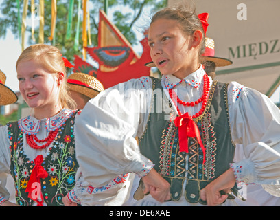 Volkstänzer in Krakauer Hauptmarkt tragen traditionelle bestickte Kleidung. Stockfoto