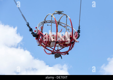 Zwei junge Damen genießen eine Achterbahnfahrt hoch in den Himmel. Stockfoto