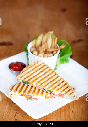 Gegrillte Caprese Sandwich mit Pommes Frites und Ketchup auf einem Teller Stockfoto