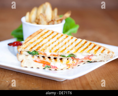 Gegrillte Caprese Sandwich mit Pommes Frites und Ketchup auf einem Teller Stockfoto