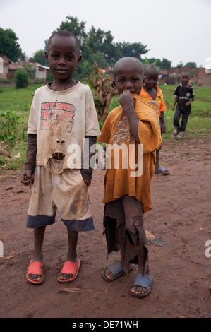 zwei afrikanische jungen zusammenstehen in Embale Uganda ungepflegt in zerrissenen Kleidern suchen Stockfoto