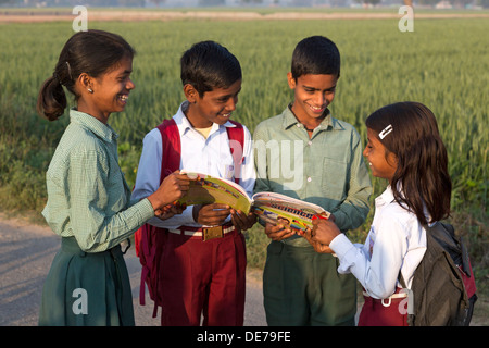 Indien, Agra, Uttar Pradesh Dorfkinder in Schuluniform Blick auf indische Lehrbuch Stockfoto