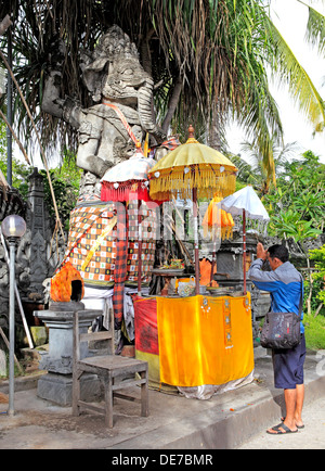 Balinesischen Mann verehren an einem Schrein mit einer Statue Ganesha, außerhalb Jagatnatha Tempel, Singaraja, Bali, Indonesien Stockfoto