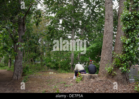 Berlin, Deutschland - zwei Männer sitzen auf einem Baumstumpf Stockfoto