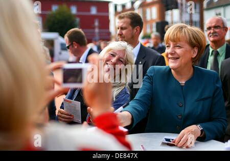 Barth, Deutschland. 13. September 2013. Bundeskanzlerin Angela Merkel (2-R) Zeichen Autogramme am Markt Platz von Barth, Deutschland, 13. September 2013. Die Bundestagswahl stattfinden am 22. September 2013. Foto: JENS Büttner/Dpa/Alamy Live News Stockfoto