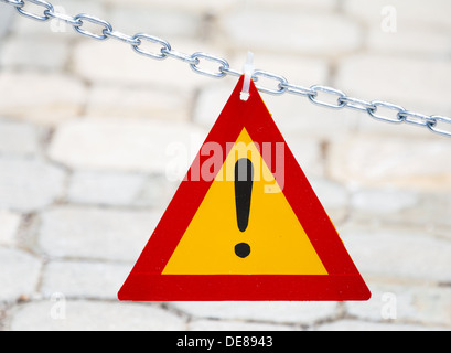 Leuchtend rote und gelbe Dreieck Ausrufezeichen hängen Metallkette Stockfoto
