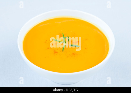 Frische Kürbissuppe in weiße Schüssel mit Rosmarin an der Spitze Stockfoto