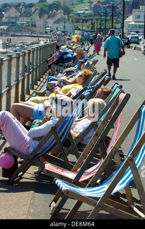 Sonnenanbeter in Liegestühlen am Strand von Sidmouth, Devon, England, Uk Stockfoto