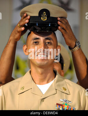 US Navy Chief Boatswain Mate Gabriel Martinez lächelt, als er seine neue Deckung am Kopf während einer Chief Petty Officer pinning Zeremonie 13. September 2013 in Camp Lemonier, Dschibuti zu platzieren hat. Achtzehn erstklassigen Unteroffiziere wurden während der Zeremonie zum Chief Petty Officer vorgerückt. Stockfoto
