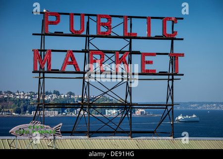 Leuchtreklame am Pike Place Market in der Innenstadt von Seattle mit einer Fähre auf dem Puget Sound, Washington, USA Stockfoto