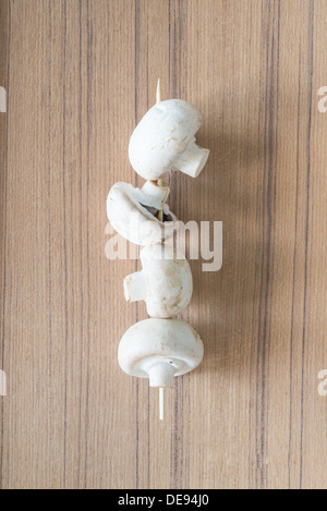 Weiße Champignons auf Holzuntergrund Stockfoto