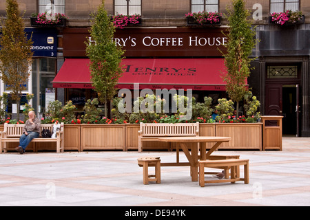 Mann sitzen Essen im Freien auf dem Stadtplatz beim Menschen genießen Erfrischungen im Inneren des Henrys Coffee House in Dundee, Großbritannien Stockfoto