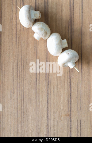 Weiße Champignons auf Holzuntergrund Stockfoto