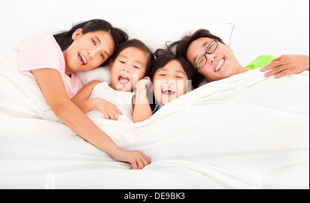 Glückliche Familie auf dem Bett Stockfoto