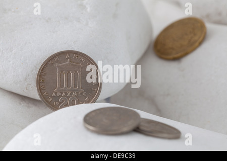 Griechische Münzen zwischen weißen Steinen Stockfoto