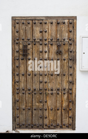 Eine alte antike Holztür mit Schmiedeeisen verzierte Verstärkungen in Ronda, Andalusien, Spanien. Stockfoto