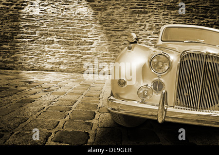 Oldtimer auf dem Steinboden vor einer Mauer Stockfoto