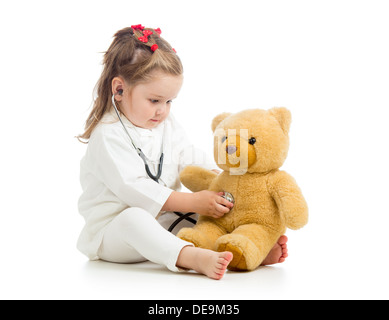 Kind Mädchen mit Kleidern des Arztes spielt mit Spielzeug Stockfoto