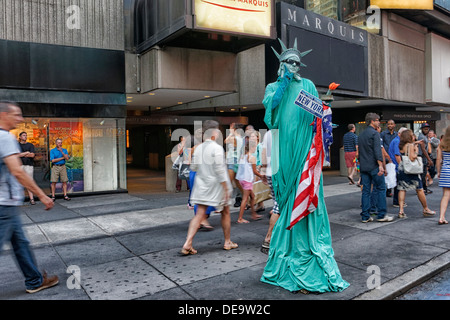 New York, MA - 11. Juli 2013: ein Darsteller gekleidet, wie Lady Liberty gehen auf Stelzen für Bild im Times Square bringt. Stockfoto