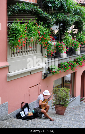 Italien - Comer See - Bellagio Stadt - Salita Serbelloni - Stufen hinauf vom See - Gitarrist unter Restaurant-Balkon Stockfoto